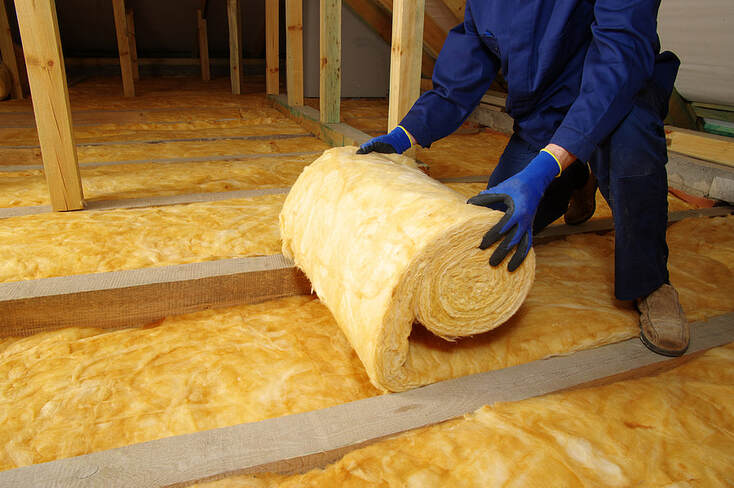 Workers install wool insulation in the attic of a house in Hartford, Connecticut.