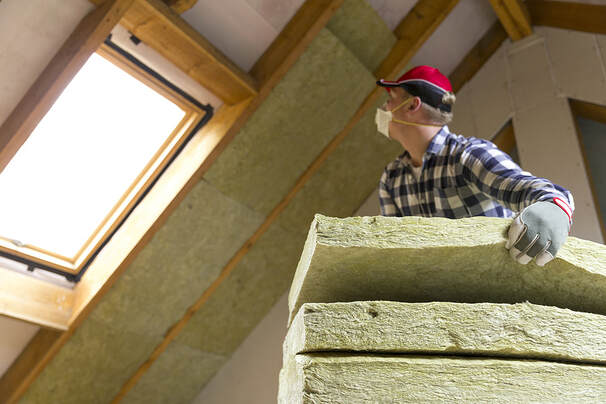 Worker installing insulation in Hartford, CT home.
